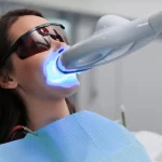Teeth whitening treatment with LED light at dental clinic