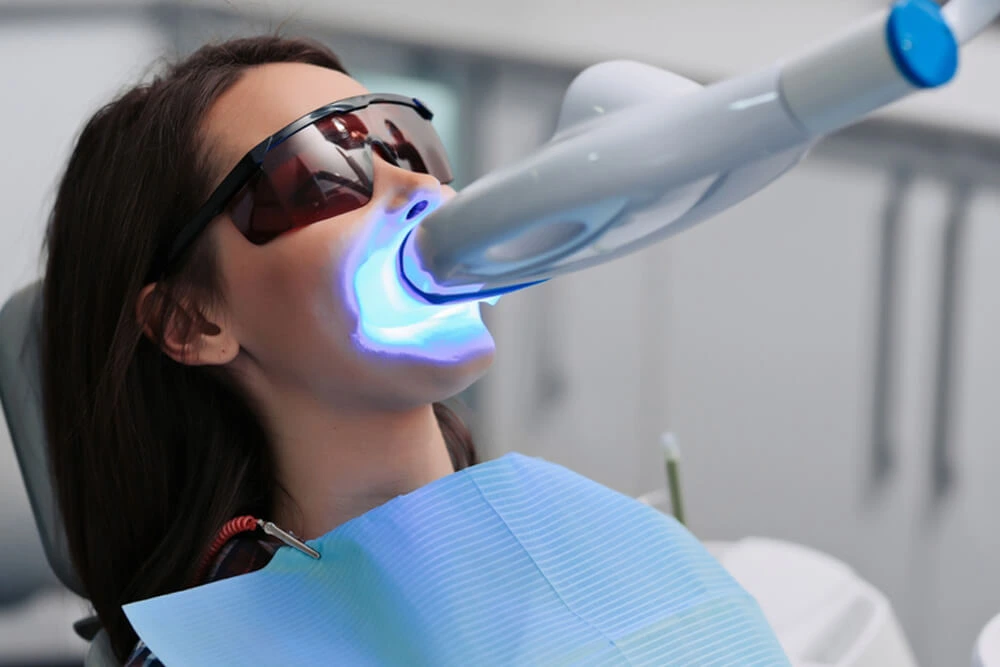 Teeth whitening treatment with LED light at dental clinic